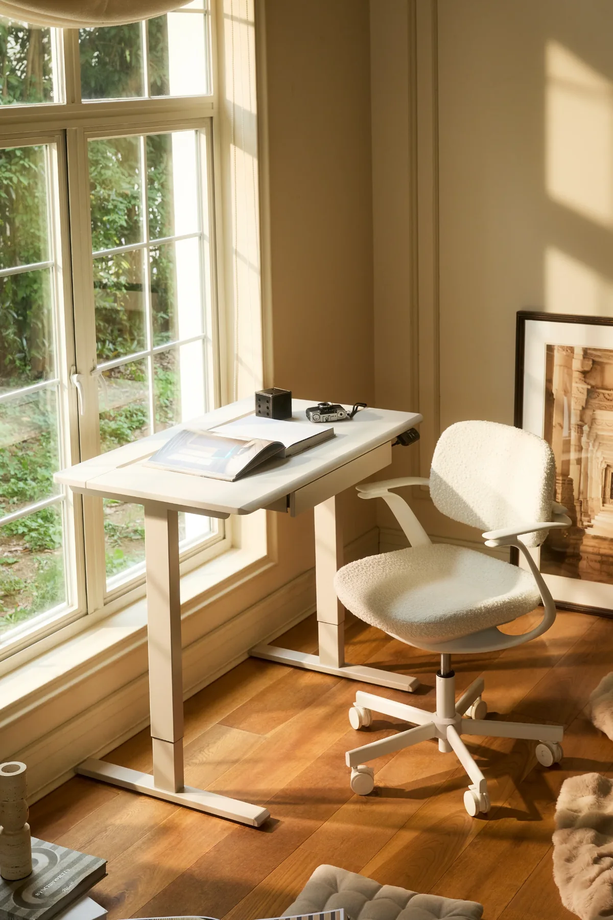 Ergonomic office chair beside a standing desk in a sunlit home office